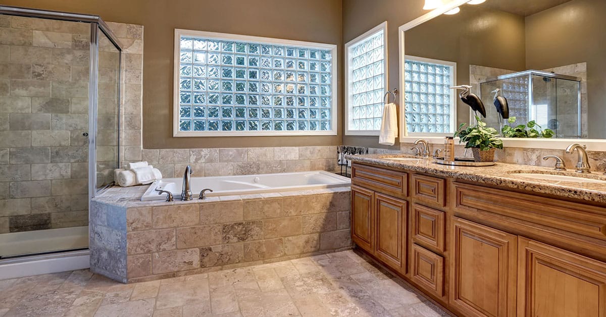 Spacious bathroom with a walk-in shower, built-in tub, and double vanity with wood cabinets.